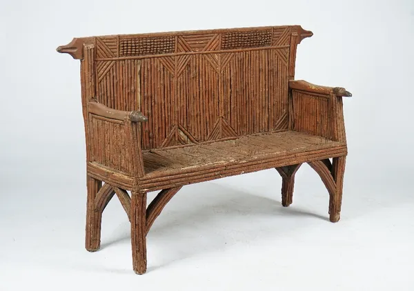 A rustic style settle with hounds' head terminals