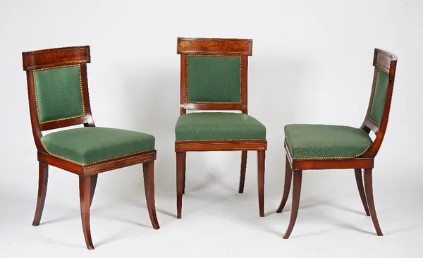 A set of eight Empire style mahogany and brass dining chairs on sabre legs