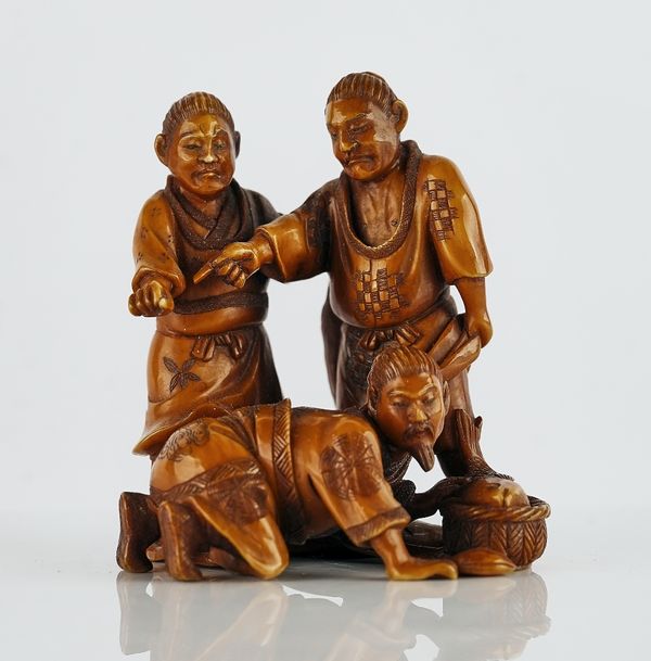 A Japanese stained ivory netsuke of three fishermen