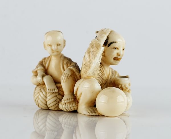 A Japanese ivory netsuke of a man and boy