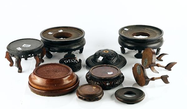 A group of twenty three Chinese wood stands and two covers