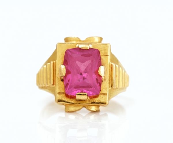 A gold and synthetic ruby single stone ring