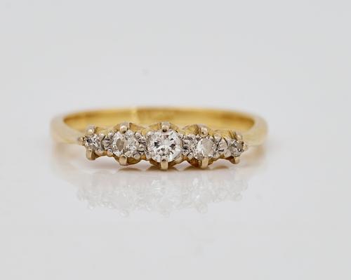 A gold and diamond set five stone ring
