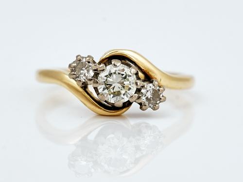 A gold and diamond three stone ring