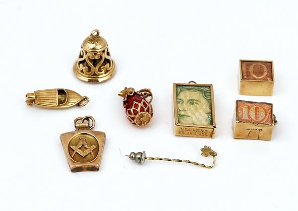 Seven mostly gold pendants and charms and a stick pin (8)