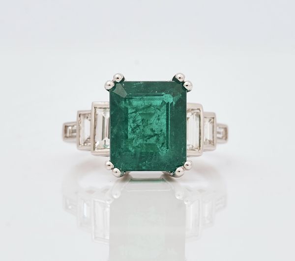 An 18ct white gold, emerald and diamond set dress ring