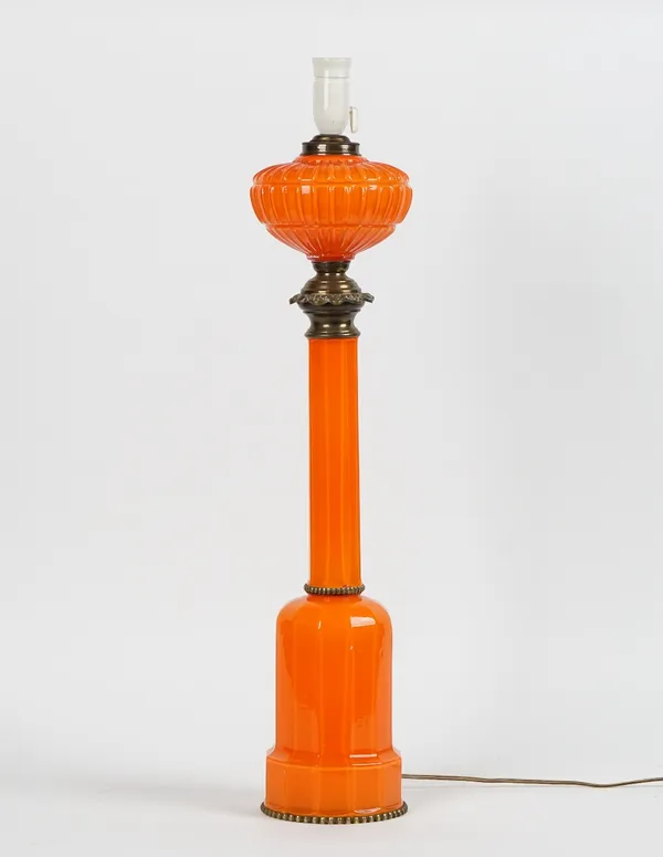 A gilt-metal and orange glass oil lamp