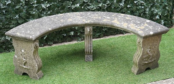 A RECONSTITUTED STONE SEMI-ELLIPTIC GARDEN BENCH, ON THREE SILHOUETTE SUPPORTS