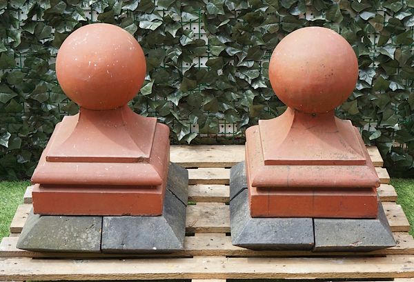 A PAIR OF TERRACOTTA GATE PIER SPHERES MOUNTED ON FOUR CAPPING STONES (10)