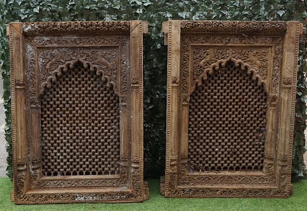 A PAIR OF 19TH CENTURY ASIAN CARVED WINDOWS, WITH INSET METAL GRILLS AND PANELLED SHUTTERS (2)