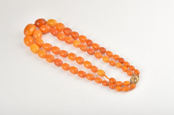 A TWO ROW NECKLACE OF VARICOLOURED OPAQUE BUTTERSCOTCH COLOURED OVAL AMBER BEADS