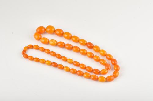 A SINGLE ROW NECKLACE OF AMBER BEADS