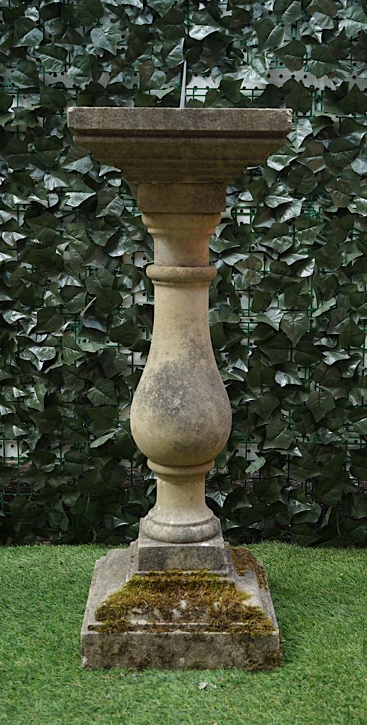 A RECONSTITUTED STONE SUNDIAL WITH BALUSTER COLUMN