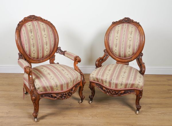 A LADY’S AND GENTLEMAN'S GRADUATED PAIR OF CARVED WALNUT FRAMED ARMCHAIRS (2)