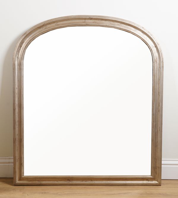 A SILVERED ARCH TOP OVERMANTEL MIRROR