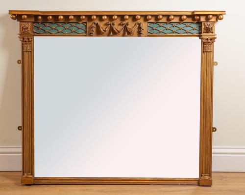 A REGENCY GILT FRAMED OVERMANTEL MIRROR WITH LATTICE FRIEZE AND FLUTED IONIC COLUMNS
