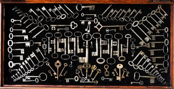 A COLLECTION OF VARIOUS STEEL KEYS LATER MOUNTED IN AN OAK DISPLAY CASE