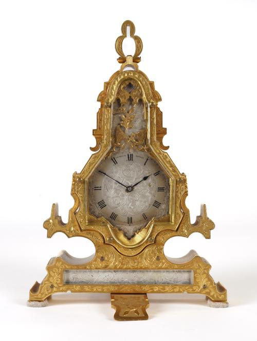 A RARE AND UNUSUAL ENGRAVED GILTBRASS STRUT TIMEPIECE