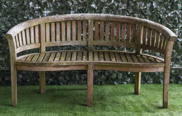 A HARDWOOD SEMI ELLIPTIC GARDEN BENCH OF SLATED CONSTRUCTION