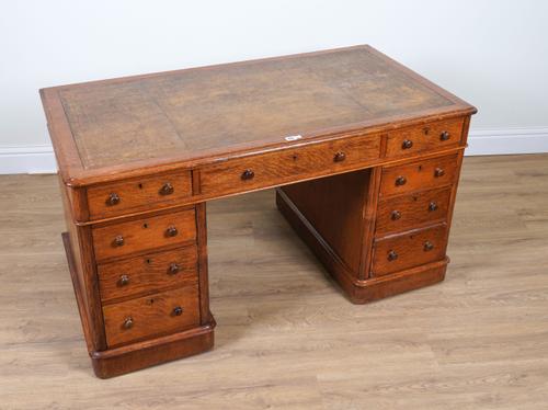 A VICTORIAN OAK NINE DRAWER PEDESTAL DESK