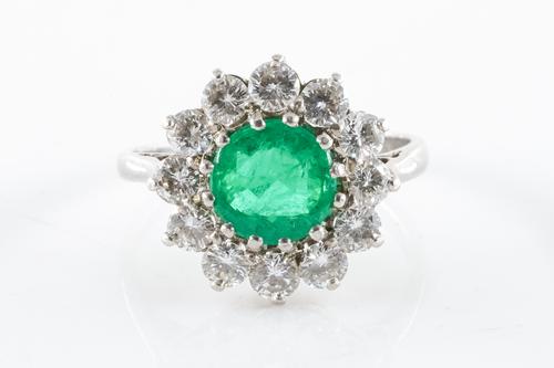 AN EMERALD AND DIAMOND CLUSTER RING