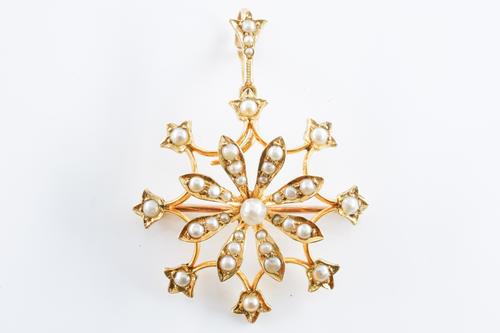 AN EDWARDIAN GOLD AND SEED PEARL SET PENDANT BROOCH