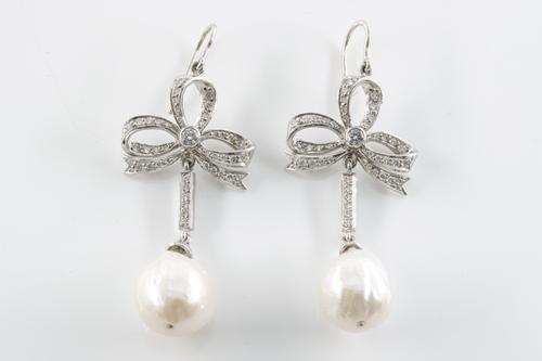 A PAIR OF DIAMOND BOW AND BAROQUE PEARL DROP EARRINGS
