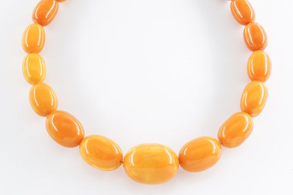 A SINGLE ROW NECKLACE OF GRADUATED BUTTERSCOTCH AMBER BEADS