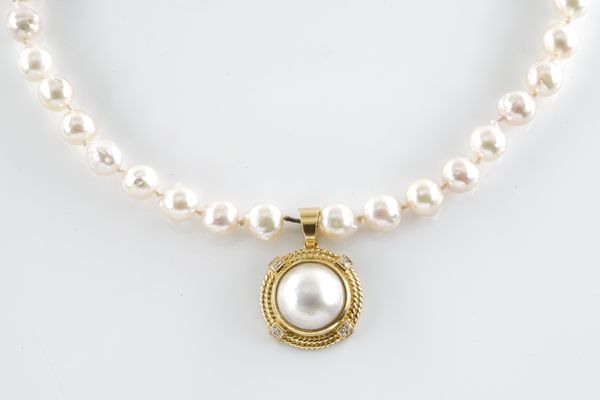 A PEARL AND DIAMOND PENDANT WITH A CULTURED PEARL STRAND