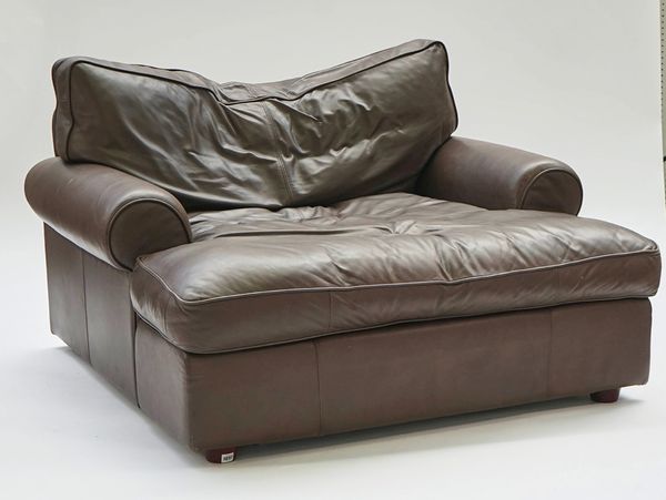 An oversized brown leather upholstered easy armchair