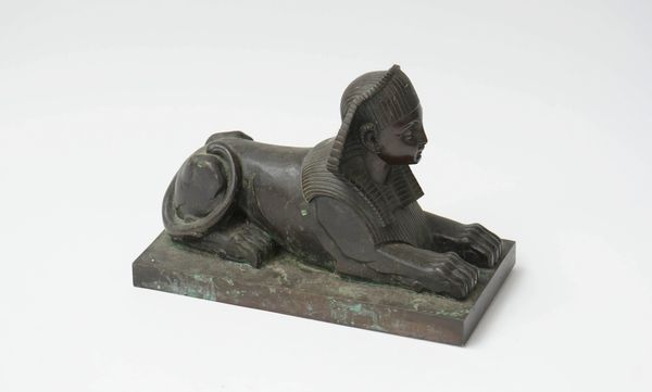 A patinated bronze model of a sphinx