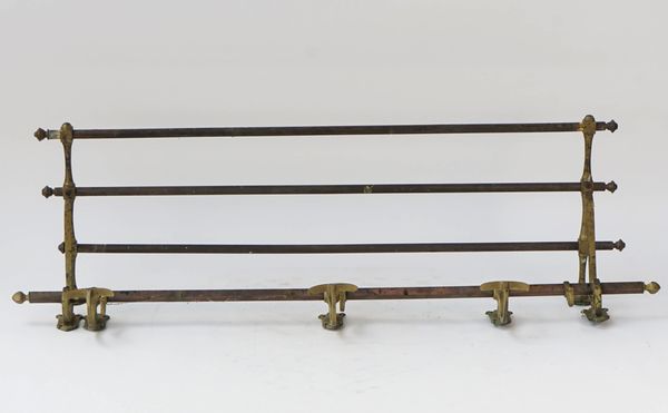 A brass wall mounted luggage rack