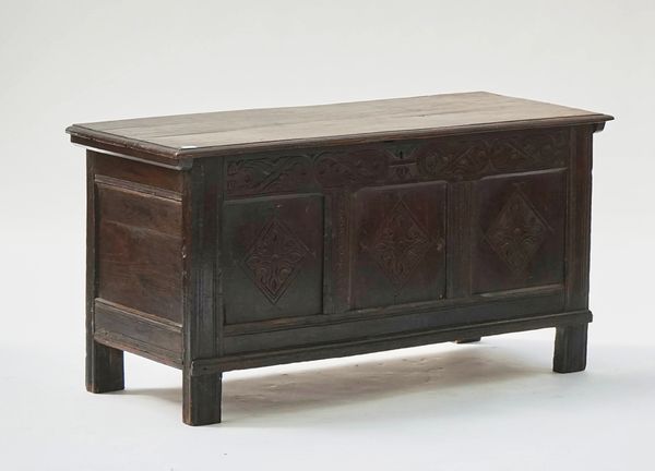 A 17TH CENTURY OAK COFFER WITH TRIPLE CARVED FRONT PANEL