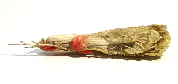 A CHINESE IVORY CARVING OF A GRASSHOPPER ON A CABBAGE LEAF