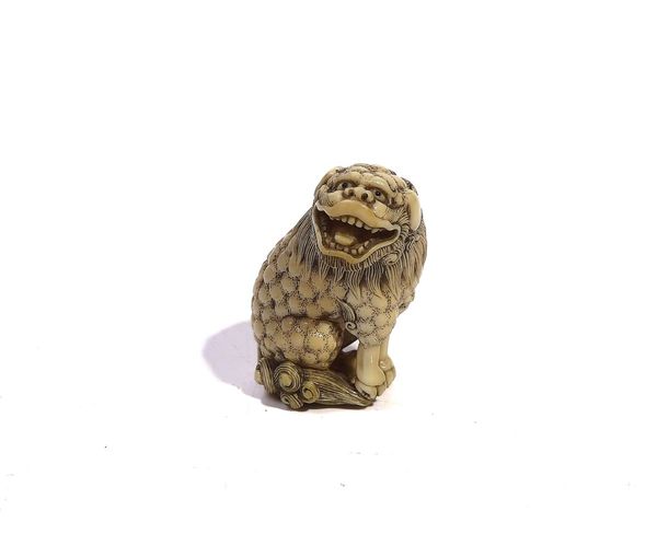 A JAPANESE IVORY NETSUKE OF A SHISHI