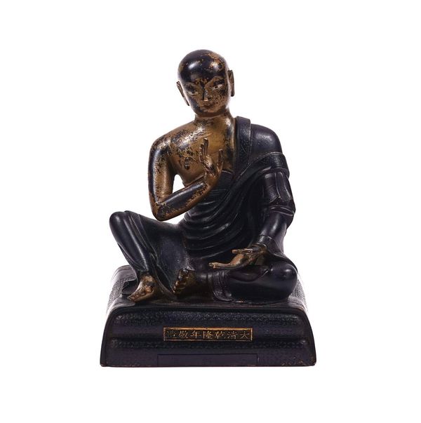 A CHINESE PARCEL- GILT BRONZE FIGURE OF A SEATED MONK