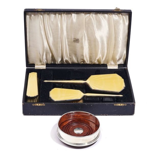 A SILVER AND YELLOW ENAMELLED THREE PIECE COMPOSITE DRESSING SET AND A SILVER MOUNTED BOTTLE COASTER