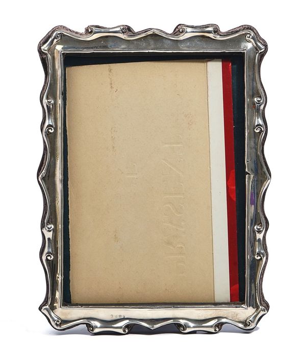 A SILVER MOUNTED SHAPED RECTANGULAR PHOTOGRAPH FRAME