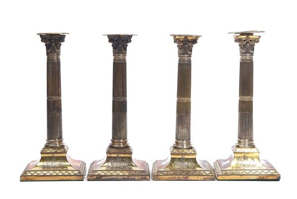 A SET OF FOUR GEORGE III GOLD PLATED ON COPPER TABLE CANDLESTICKS (4)