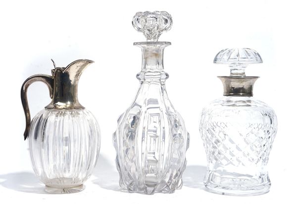 A SILVER MOUNTED GLASS CLARET JUG AND TWO FACETED GLASS DECANTERS (3)