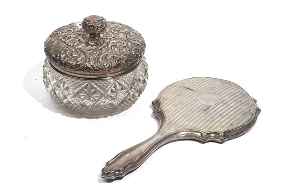 A SILVER LIDDED FACETED GLASS POWDER BOWL AND A SILVER MOUNTED HAND MIRROR (2)