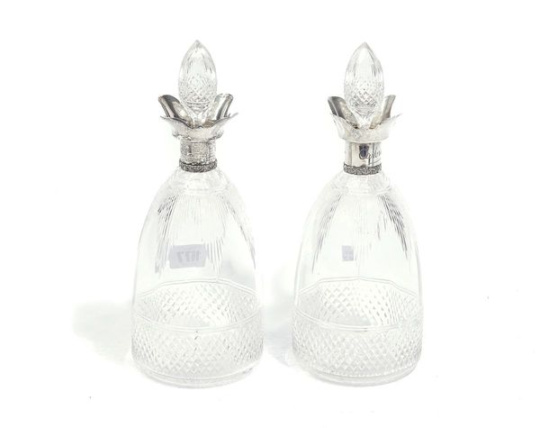 A PAIR OF SILVER MOUNTED FACETED GLASS DECANTERS AND STOPPERS (2)