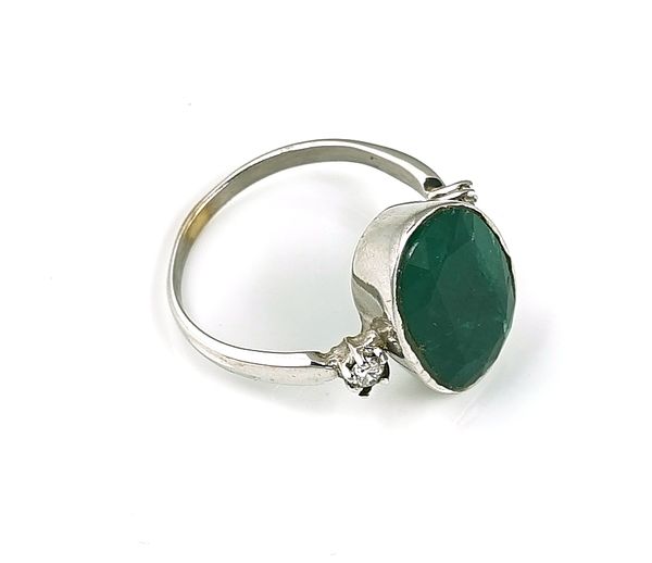 AN EMERALD AND DIAMOND THREE STONE RING