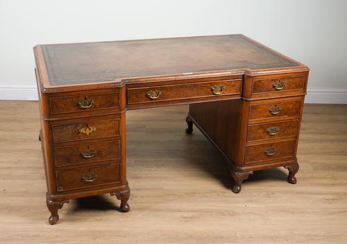 AN EARLY 20TH CENTURY WALNUT INVERTED BREAKFRONT NINE DRAWER PEDESTAL DESK