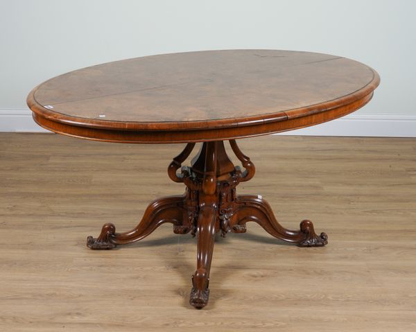 A VICTORIAN FIGURED WALNUT OVAL SNAP-TOP CENTRE TABLE ON CARVED BASE