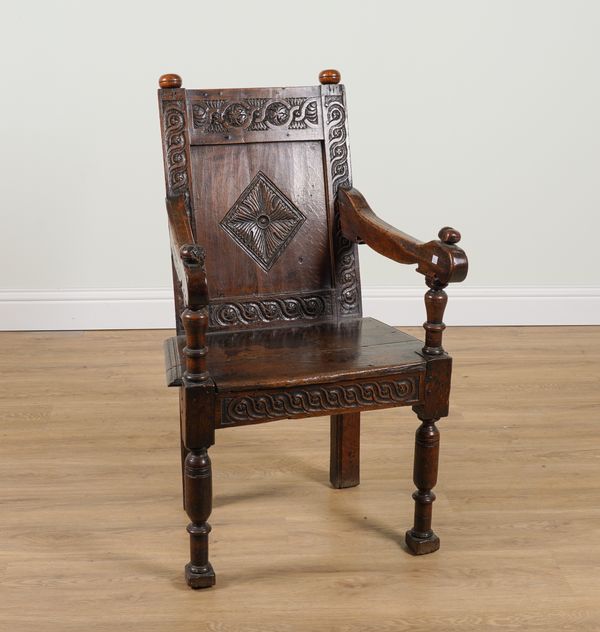 A 17TH CENTURY AND LATER OAK CARVED PANEL BACK WAINSCOT CHAIR