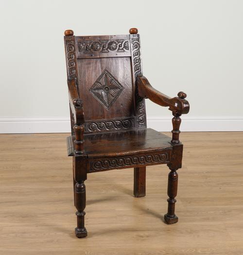 A 17TH CENTURY AND LATER OAK CARVED PANEL BACK WAINSCOT CHAIR