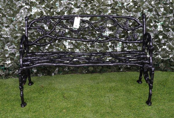 A BLACK PAINTED NATURALISTICALLY CAST-IRON GARDEN BENCH