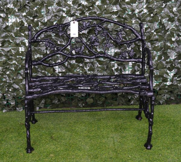 A BLACK PAINTED NATURALISTICALLY CAST-IRON GARDEN BENCH