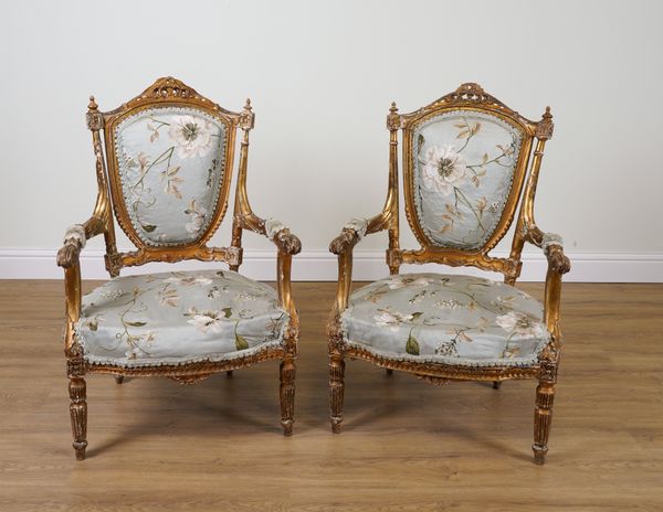 A PAIR OF 19TH CENTURY GILT FRAMED SHIELD BACK OPEN ARMCHAIRS ON FLUTED SUPPORTS (2)